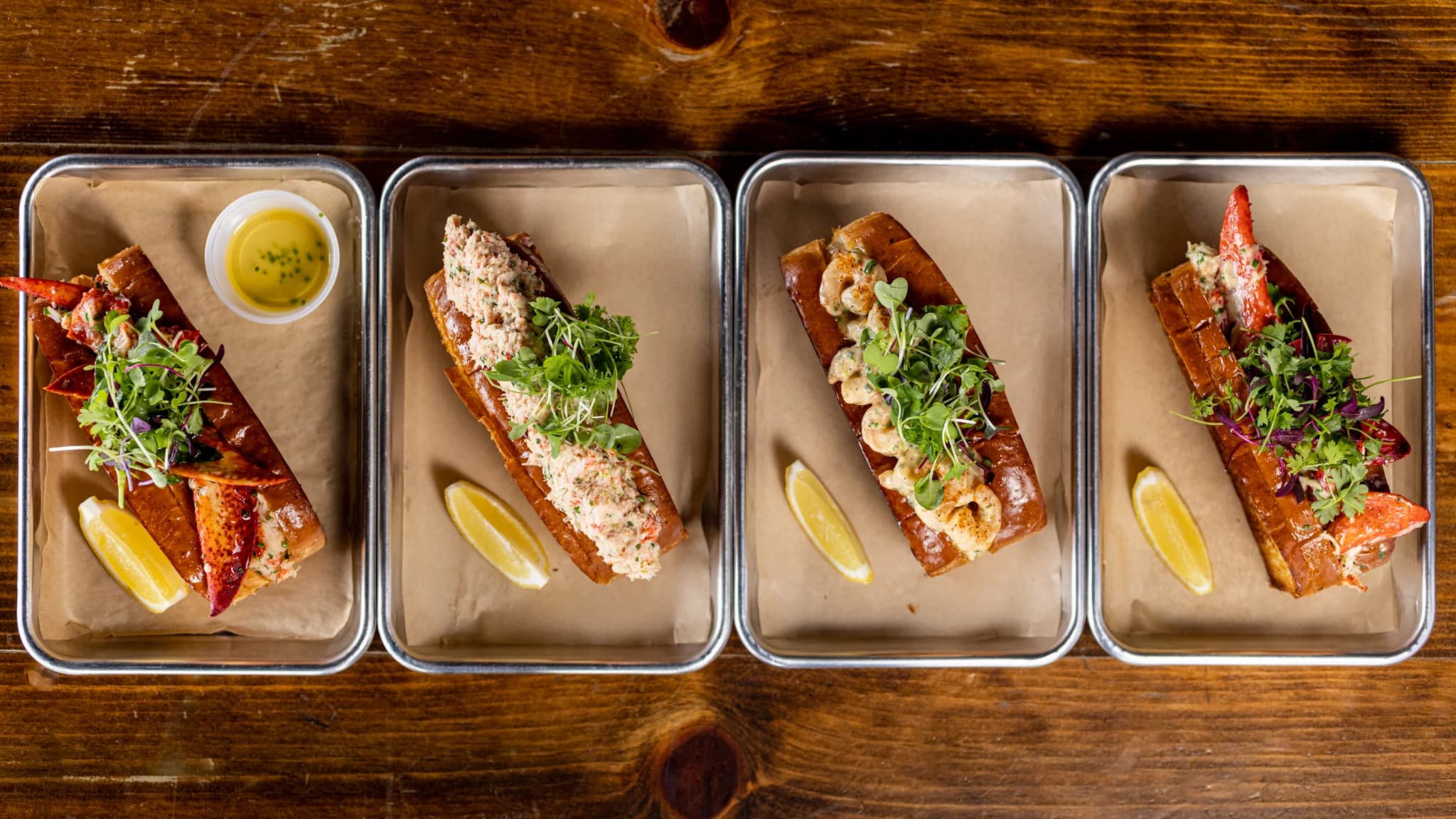 Four Lobster Lab rolls on steel trays, lobster with drawn butter, crab, shrimp and Connecticut style